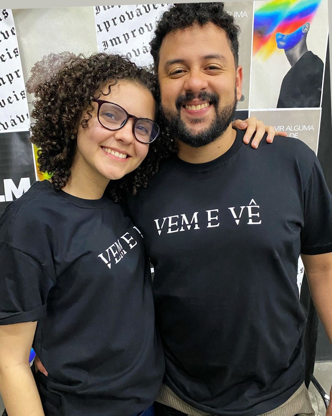 Casal usando camisas pretas da festividade com estampa Vem e Vê