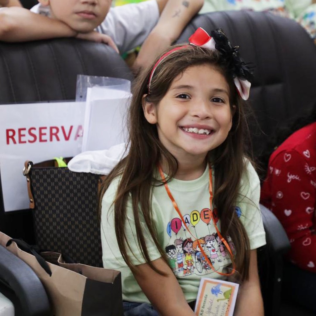 Criança sorrindo com a camiseta da festividade
